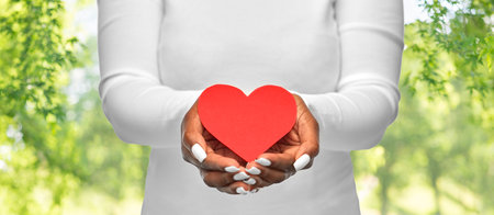 close up of african american woman with red heart