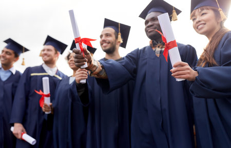 graduate students in mortar boards with diplomasの写真素材