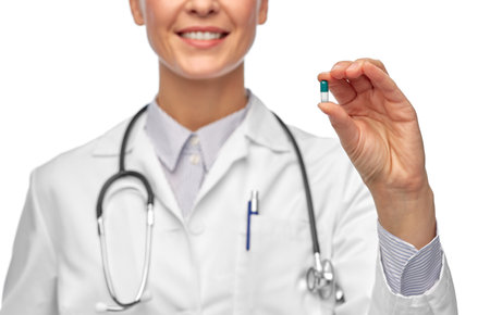 smiling female doctor holding medicine pillの写真素材