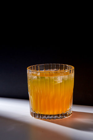 glass of orange juice with ice on tableの写真素材