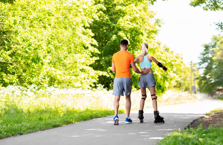 happy couple with roller skates riding outdoorsの写真素材