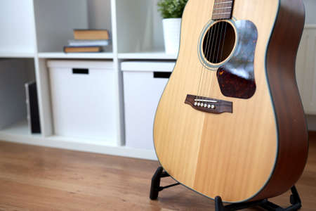 close up of acoustic guitar on stand at home