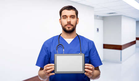 doctor or male nurse showing tablet computerの写真素材