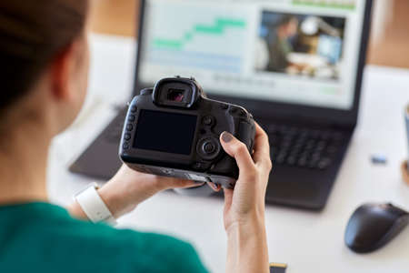 woman with camera and video editor on laptopの写真素材