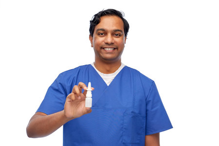smiling indian male doctor or nurse with medicineの写真素材