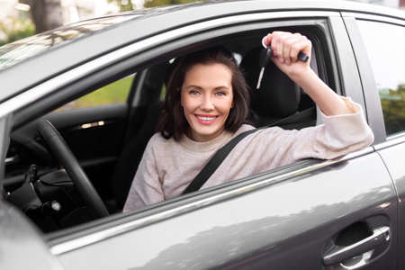 woman or female driver with car key in city