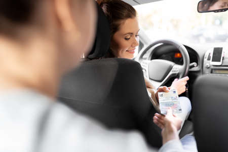 female car driver taking money from passenger