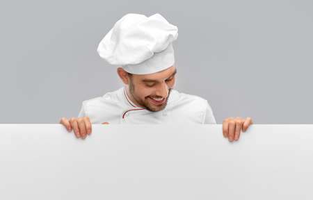 happy smiling male chef with big white boardの写真素材