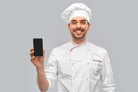 happy smiling male chef showing smartphone