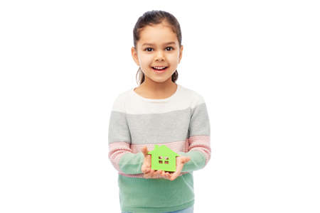 smiling little girl holding green house iconの写真素材