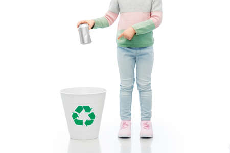 girl throwing tin can into rubbish bin