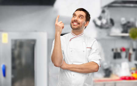 happy smiling male chef pointing finger upの写真素材