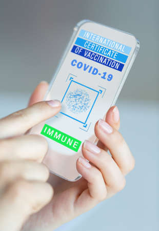 hand holding phone with certificate of vaccination