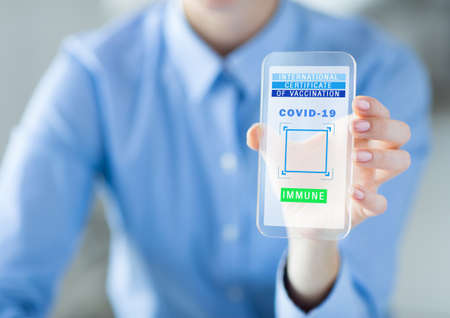 hand with virtual immunity passport on smartphoneの写真素材