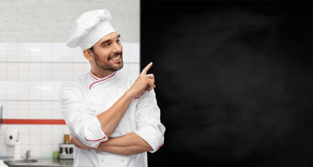 happy smiling male chef with big black chalkboardの写真素材