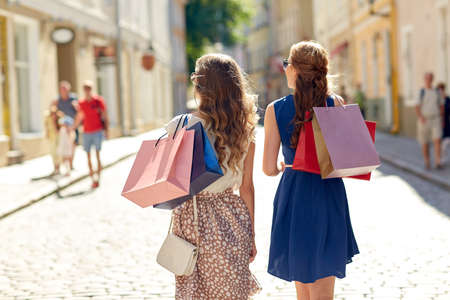women with shopping bags walking in cityの写真素材