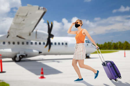 woman in mask with travel bag over plain