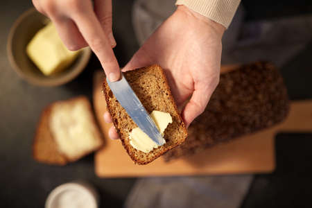 female baker spreading butter on homemade bread