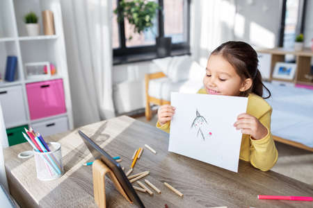 girl drawing and having video call on tablet pc
