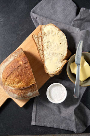 close up of bread, butter, knife and salt on towelの写真素材