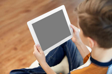 close up of boy with tablet pc computer at home