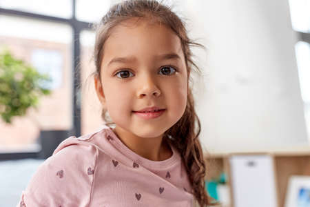 happy smiling little girl sitting on bed at home