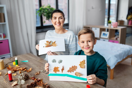 mother and son making pictures of autumn leavesの写真素材