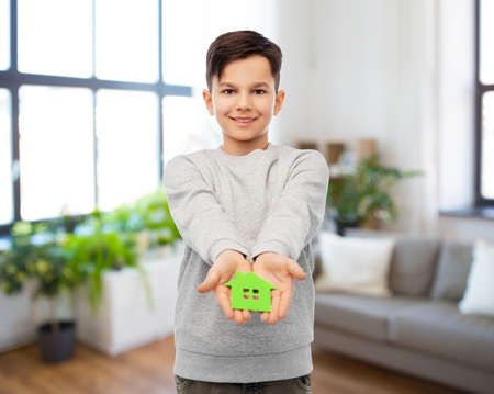smiling boy holding green house iconの写真素材