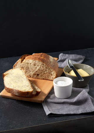 close up of bread, butter, knife and salt on towelの写真素材