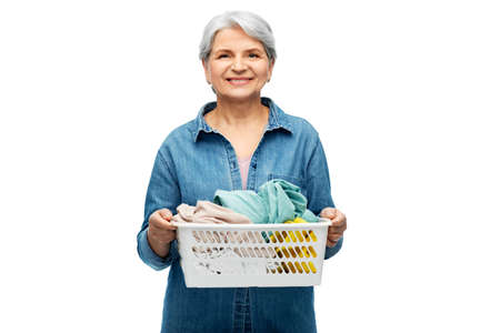 smiling senior woman with laundry basketの写真素材