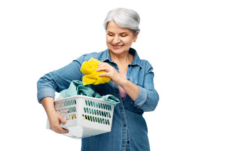 smiling senior woman with laundry basketの写真素材