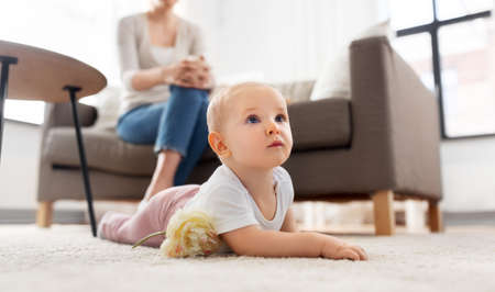 mother and baby crawling on floor at homeの写真素材