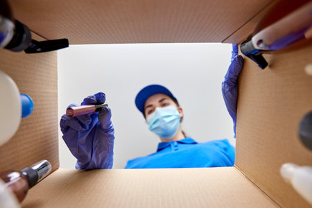 woman in mask packing parcel box with cosmetics