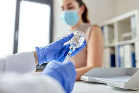 female doctor with syringe vaccinating patient