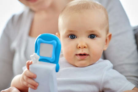 mother with baby playing with toy phone at home