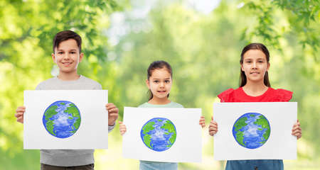 smiling children holding drawing of earth planetの写真素材