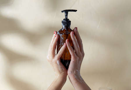 hands with bottle of shower gel or liquid soapの写真素材