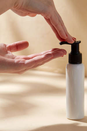 close up of hands with bottle of body lotionの写真素材