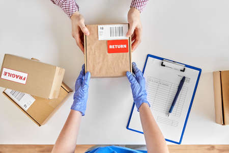 health protection, delivery and mail service concept - customer making return of parcel or purchase...