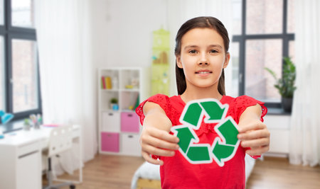 smiling girl holding green recycling signの写真素材