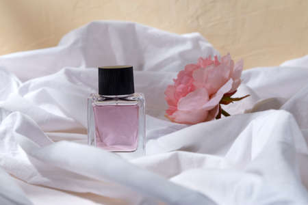 bottle of perfume and flower on white sheetの写真素材