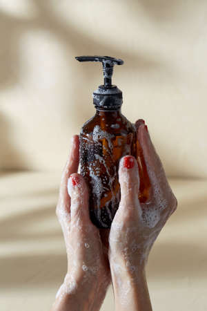 hands with bottle of shower gel or liquid soapの写真素材
