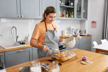woman cooking food and baking buns at home kitchen