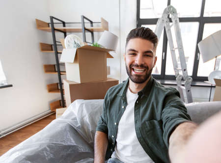 man having video call and moving into new homeの写真素材