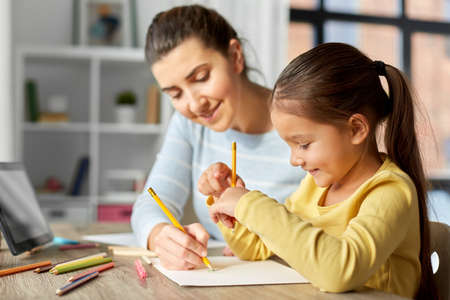 mother with little daughter drawing at homeの写真素材