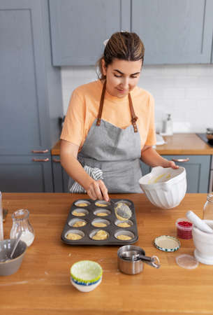woman cooking food and baking on kitchen at homeの写真素材