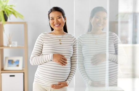 happy pregnant asian woman at homeの写真素材
