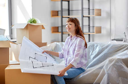 woman with blueprint and boxes moving to new home