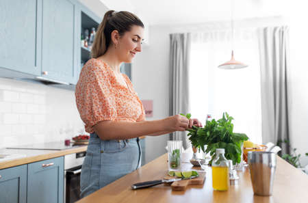 woman making cocktail drinks at home kitchen