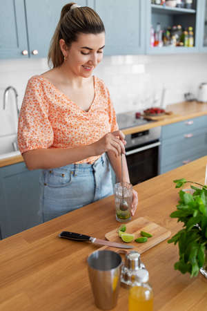 woman making cocktail drinks at home kitchen
